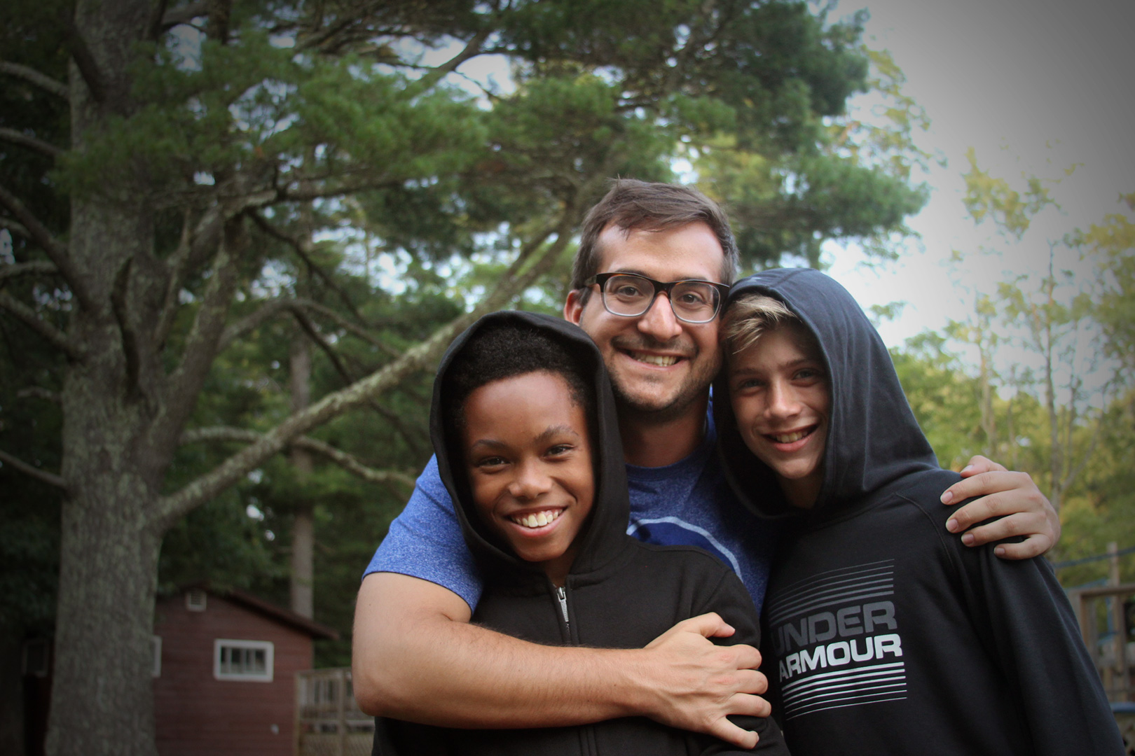 two boys being embraced by a counselor