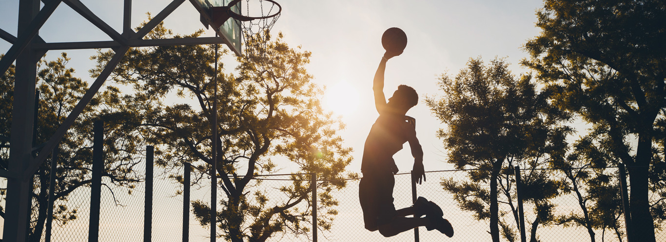 boy playing basketball in the sunlight