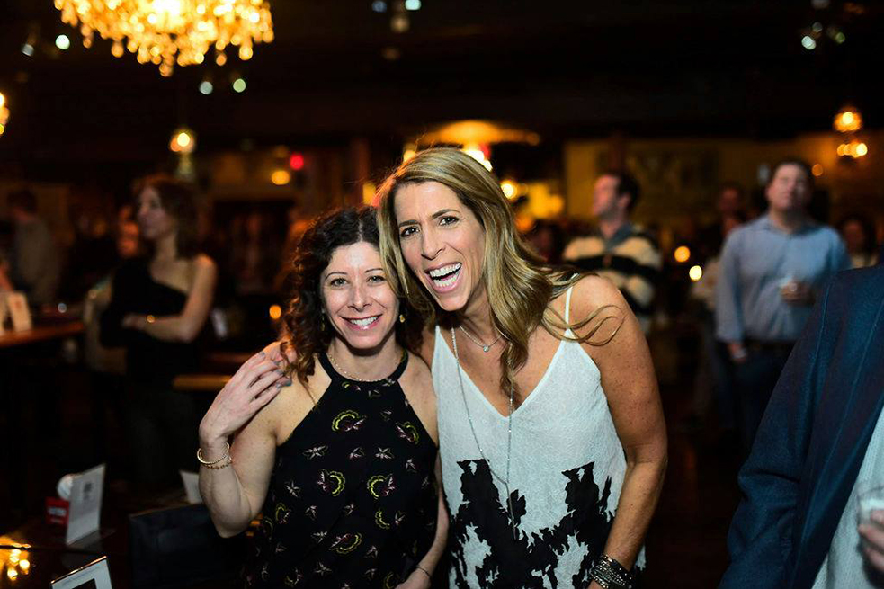 two women laughing and smiling at camera