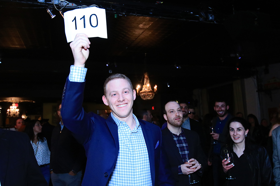 bidder holding up sign at auction