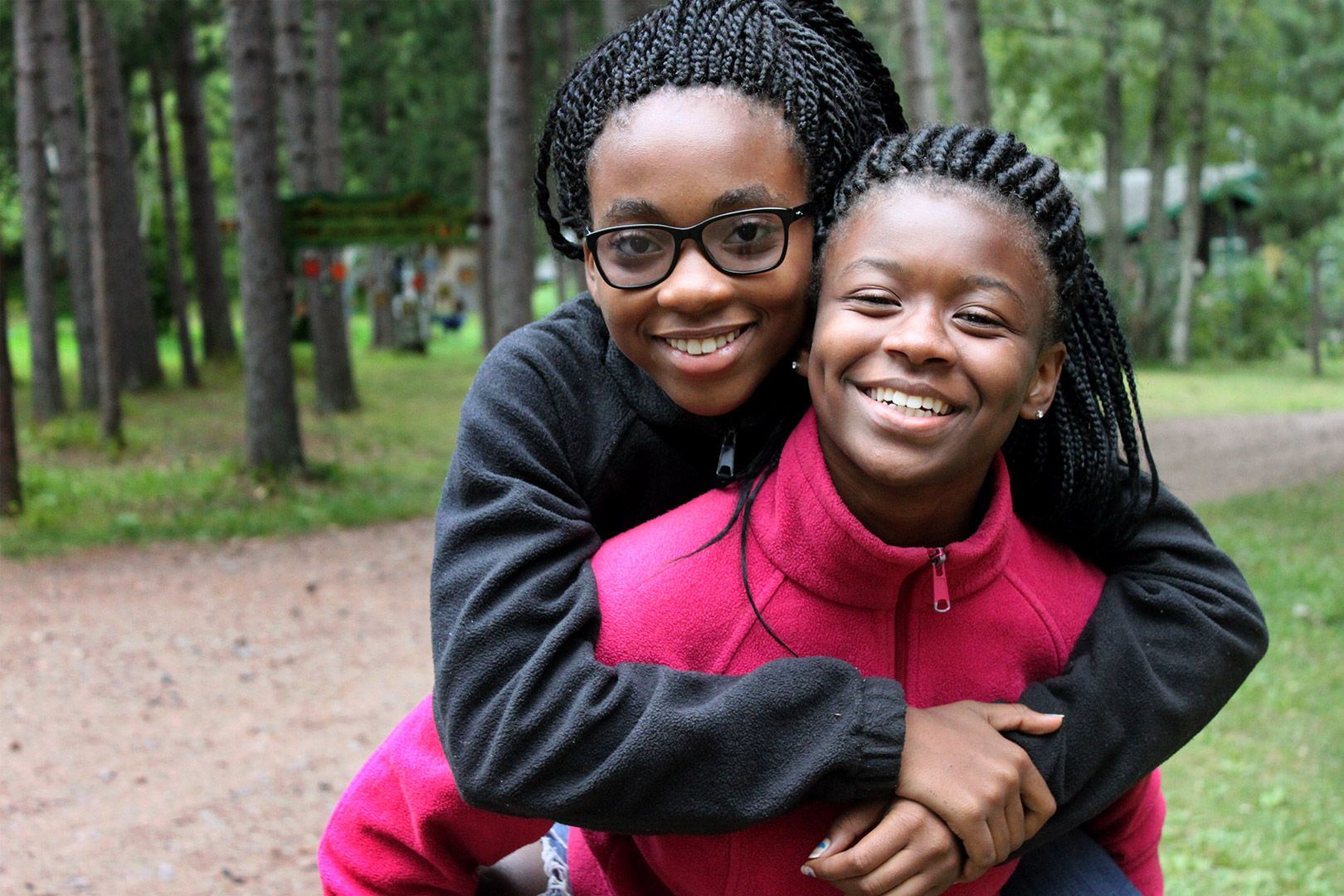 two girls with beautiful braids smiling at camera